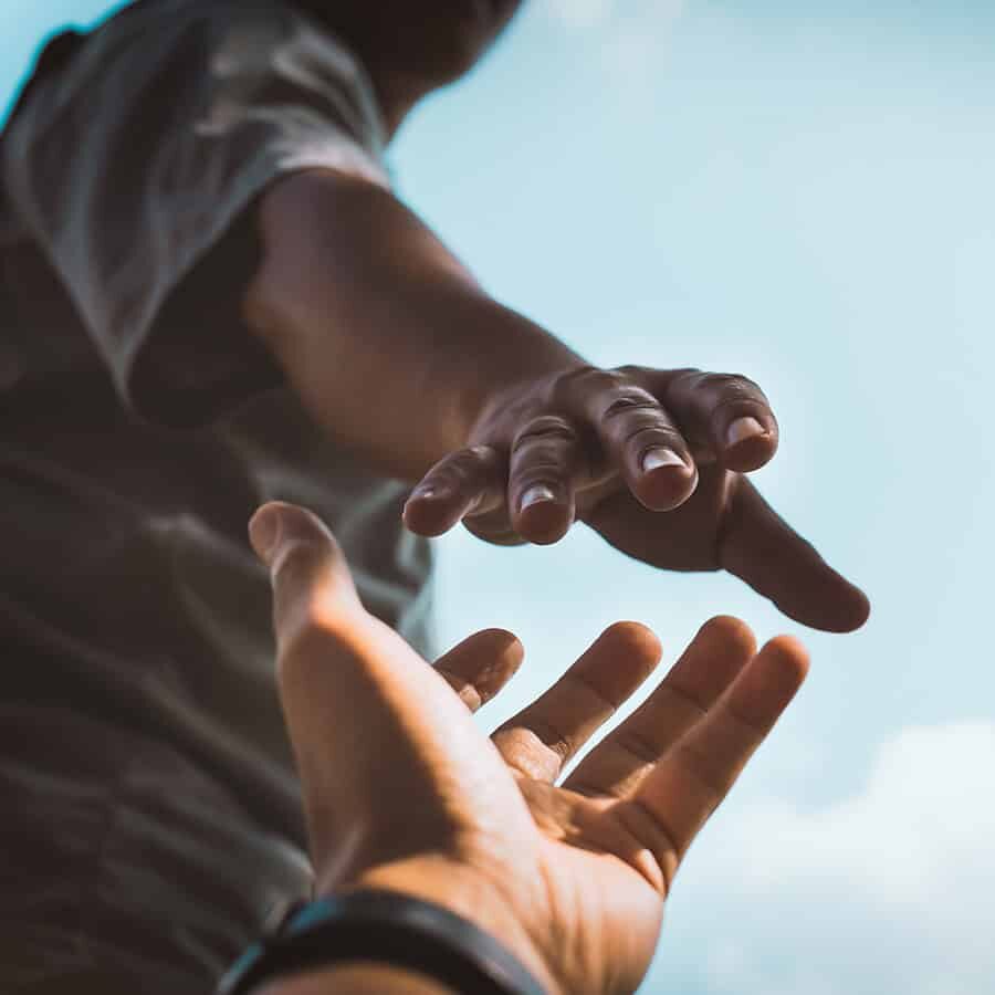 Help Concept hands reaching out to help each other in dark tone