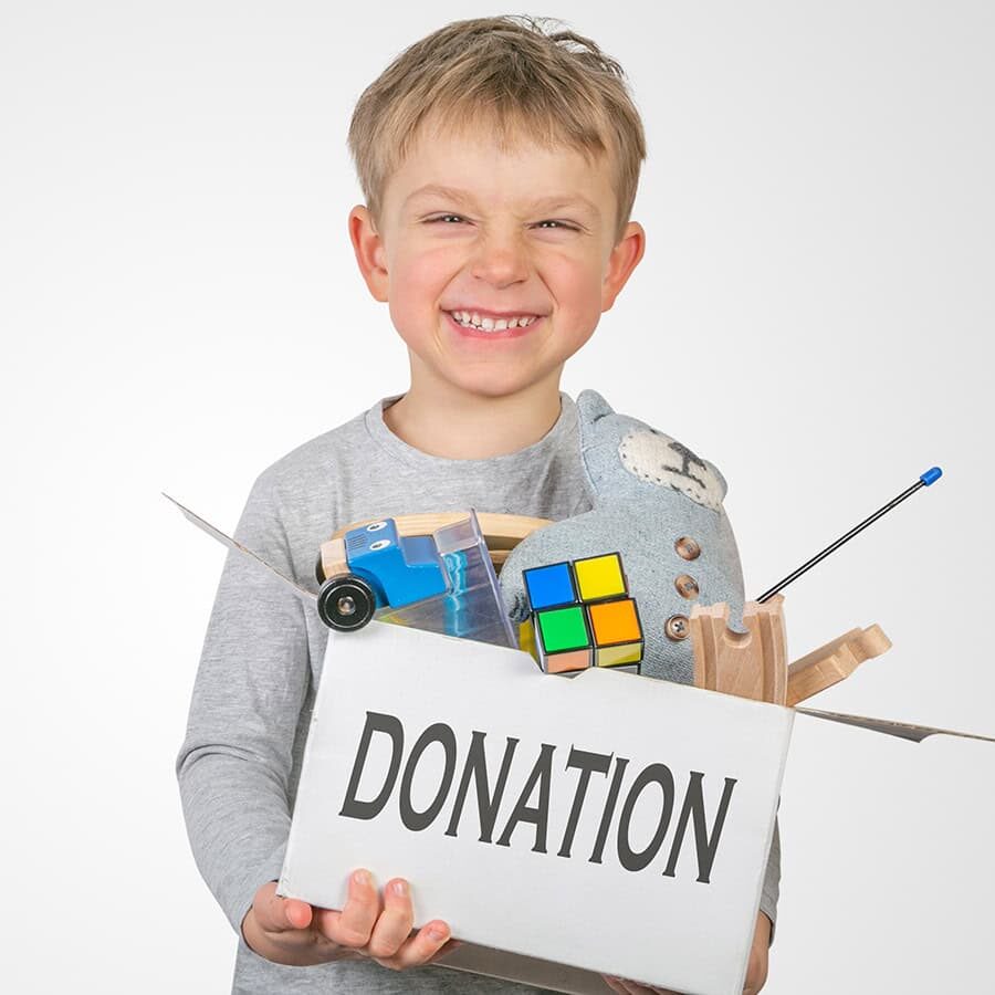 Donation concept - boy holding box with toys for donation, copy space, isolated